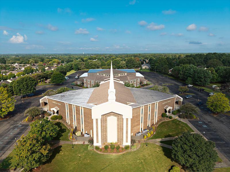 Aerial view of a church with a white steeple and its campus