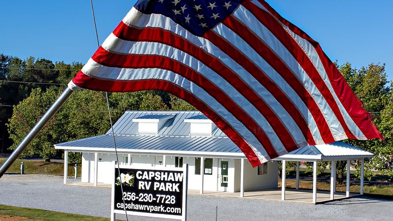 Low aerial of an RV park office with a waving American flag