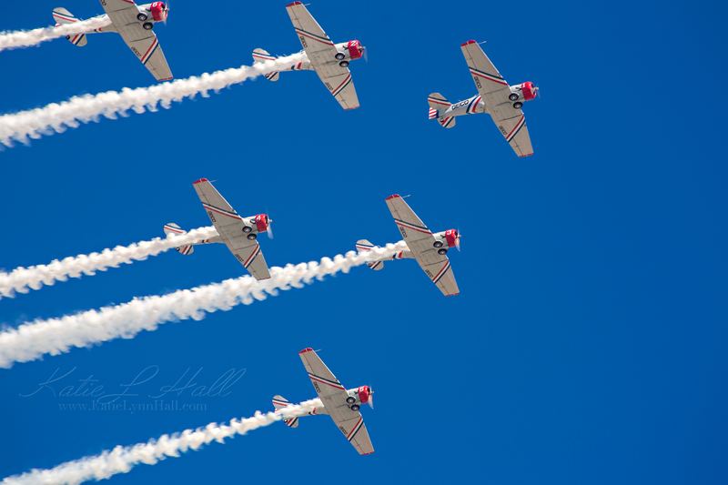 Aerobatic planes flying in formation trailing white smoke