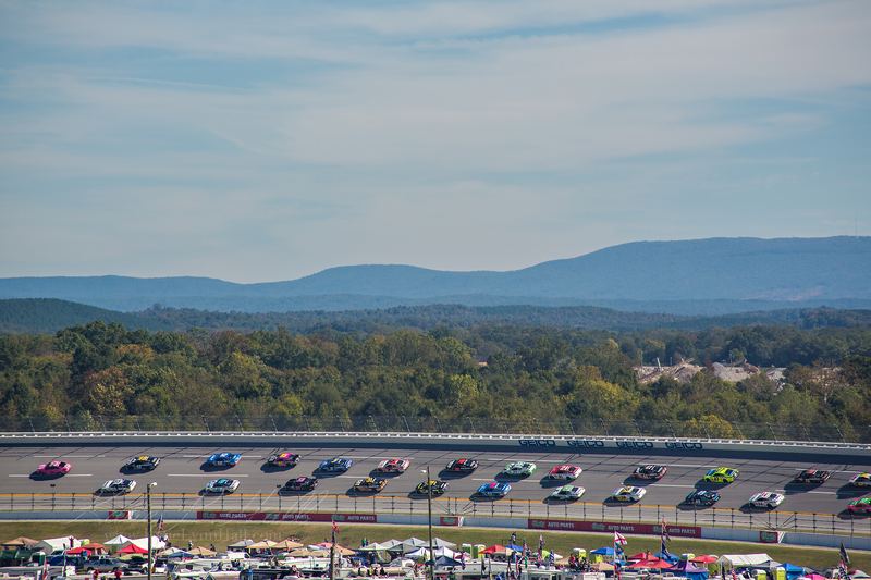 Race day at a speedway with mountains behind