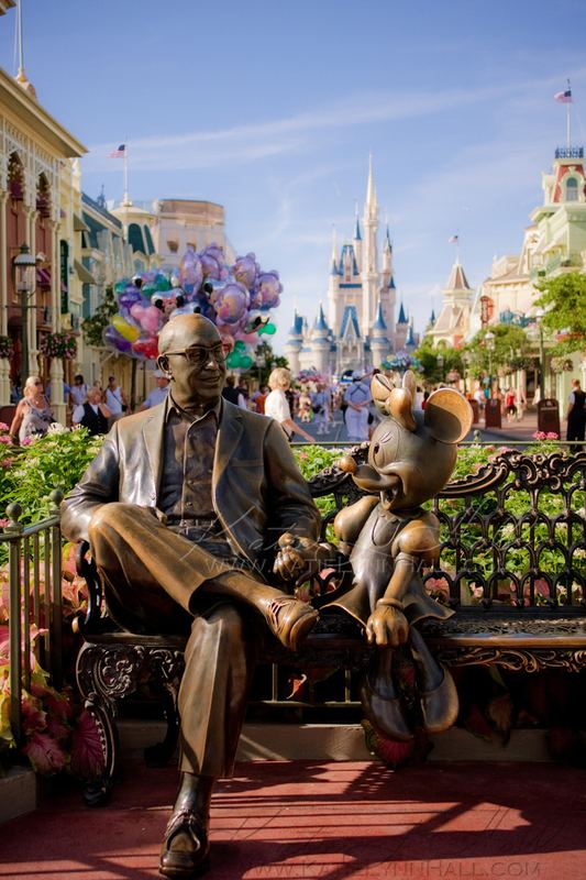 Bronze statue on a park bench with a castle behind