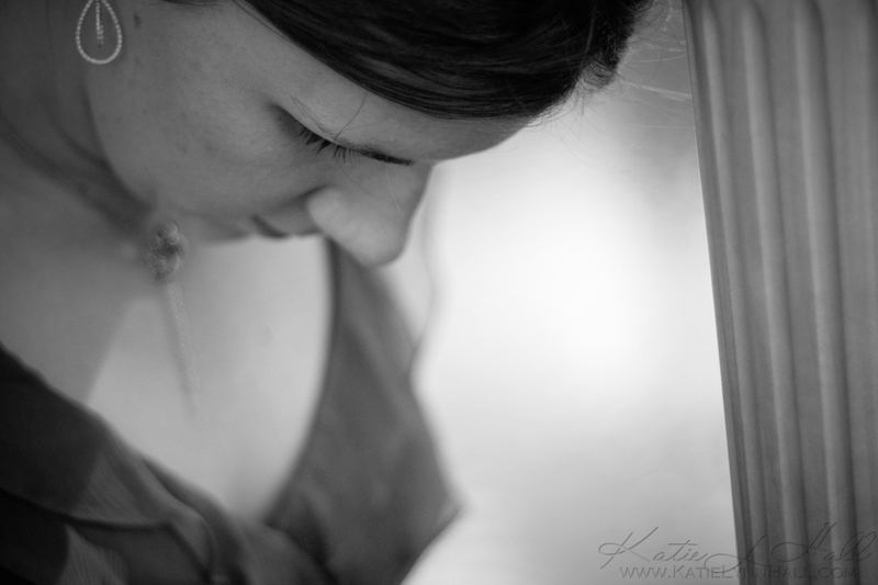 Black and white portrait of a woman looking down by a window