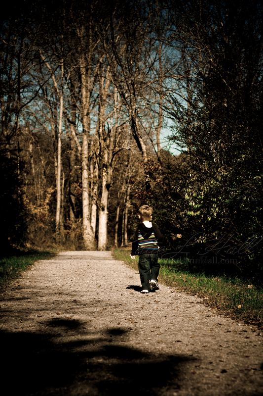 Child walking down a wooded path in autumn