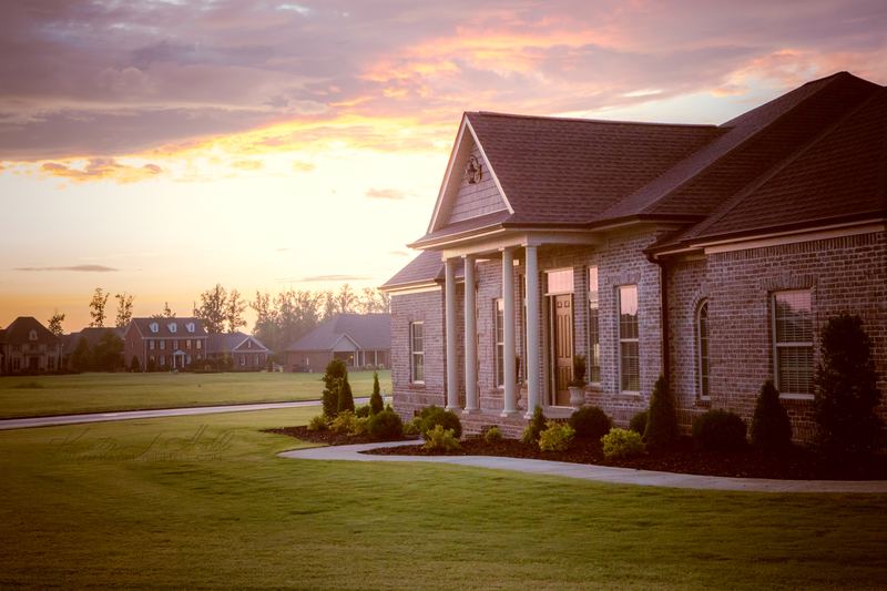 Brick home with columns at sunset
