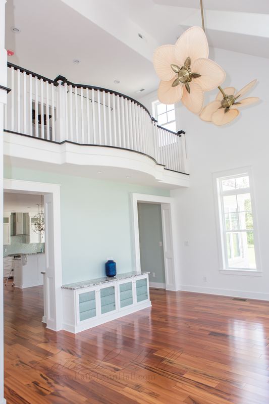 Two-story great room with a curved balcony and hardwood floors