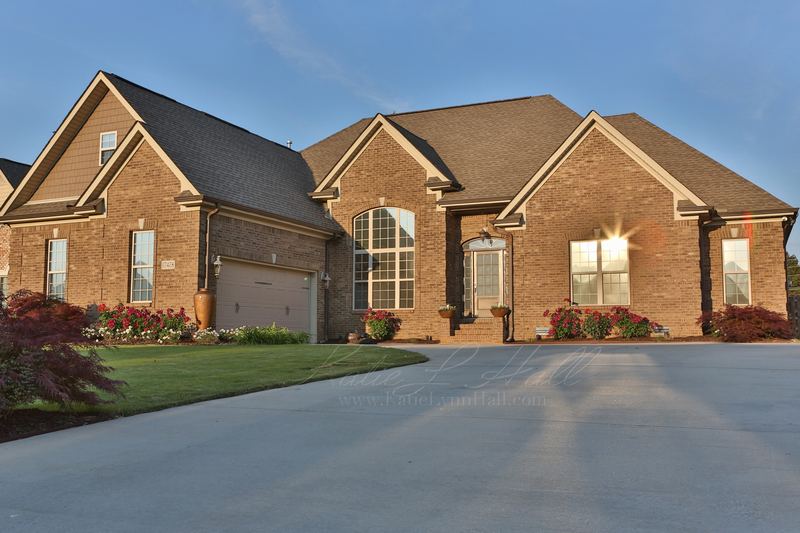 Brick home in late-afternoon sun with a long driveway